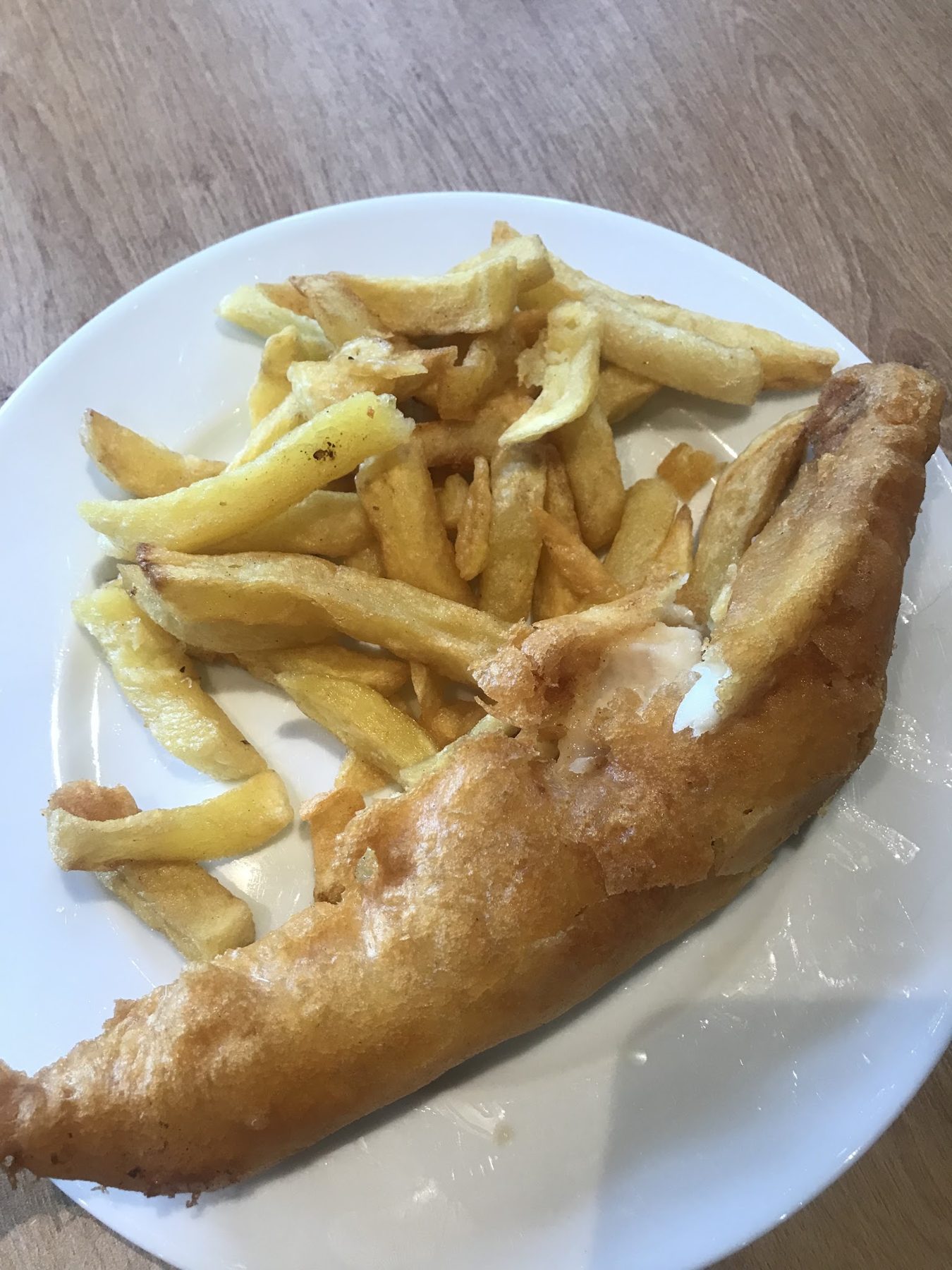 Battered fish and chips on a white plate