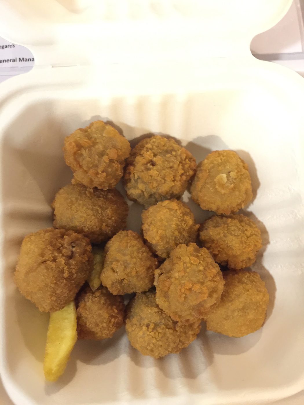 Battered mushrooms with chips in a takeaway box