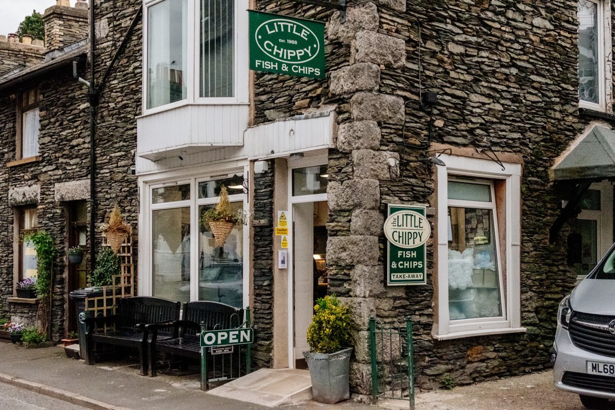 The stone-fronted shop with green The Little Chippy Fish & Chips signs and an OPEN sign